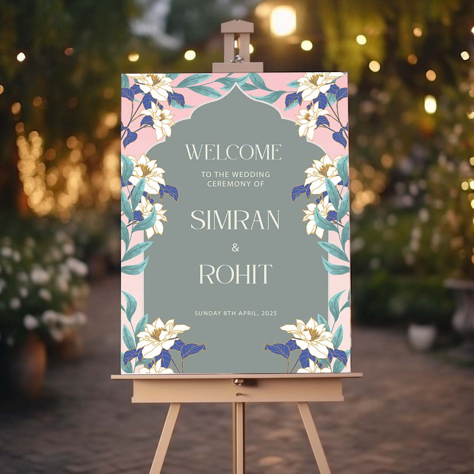 Wedding welcome sign on an easel with floral design against a blurred outdoor background.