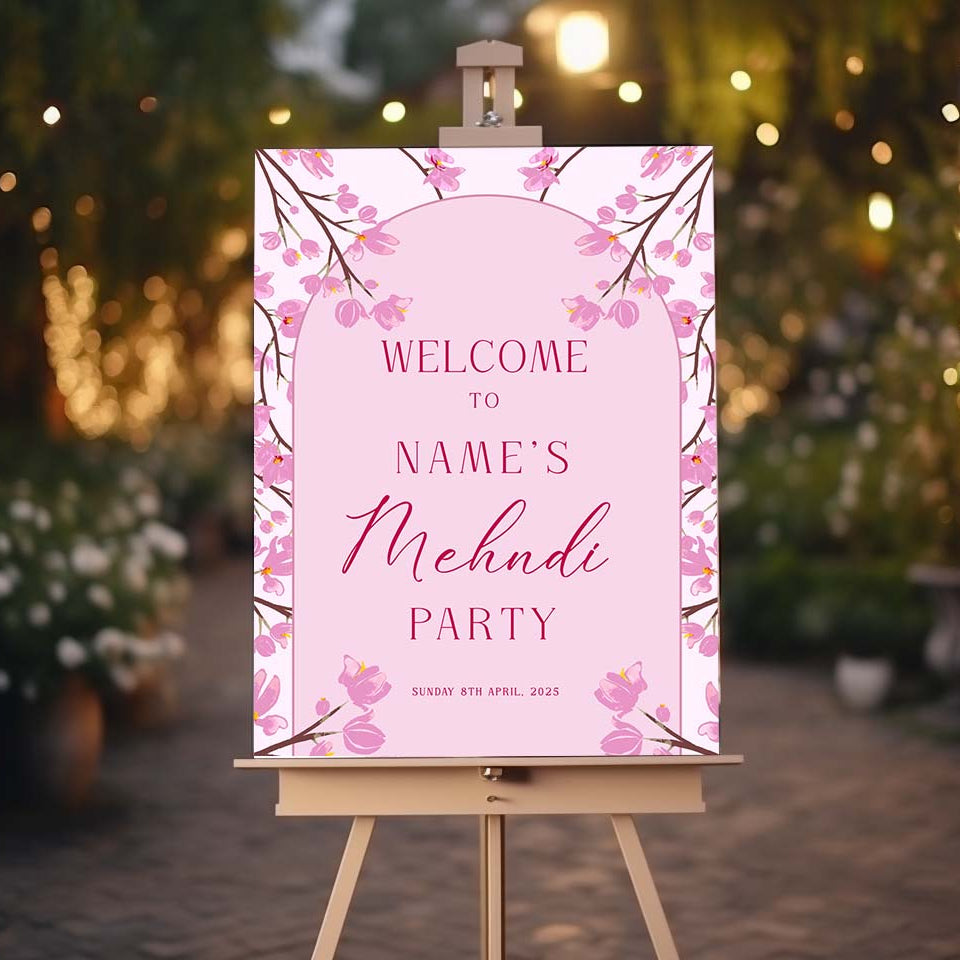 Decorative sign for a Mehndi party on an easel with a blurred festive background.